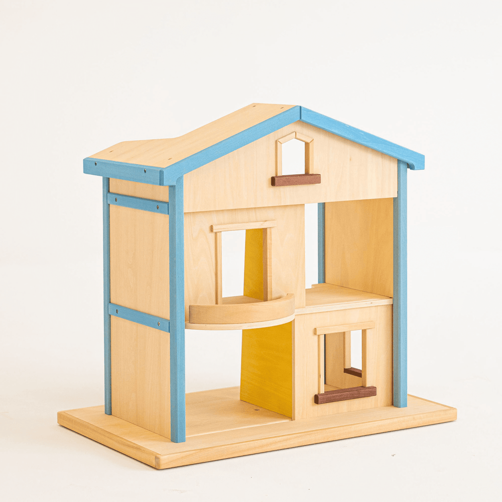 A wooden dollhouse with a blue roof, featuring two stories, an attic, and a balcony. It has a rotating platform, sliding doors, and a ladder.