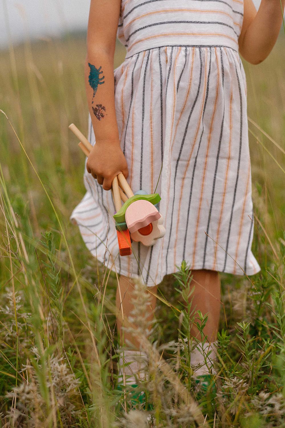 A girl grabs a bunch of wooden flowers in pink,white and orange