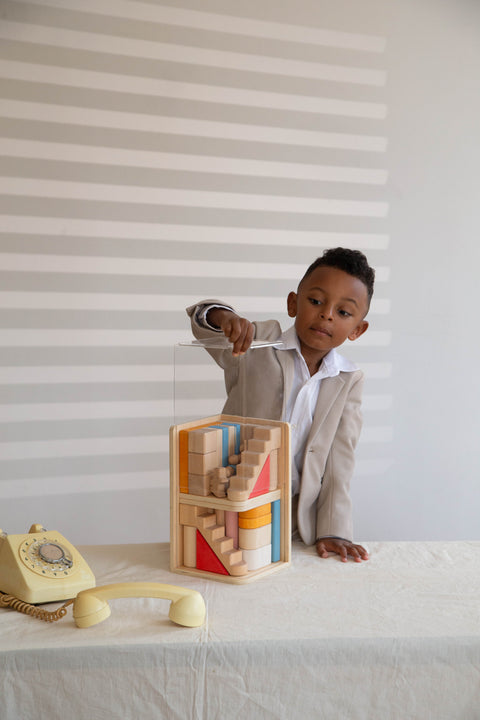 A boy open the transparent dust guard of multi-floor block set