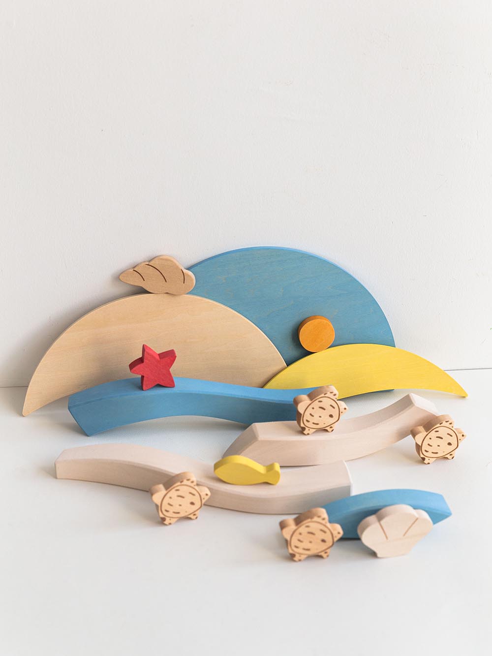 The display of the elements of the wooden puzzle toy featuring colorful layers and turtle figures on a round carrying tray.