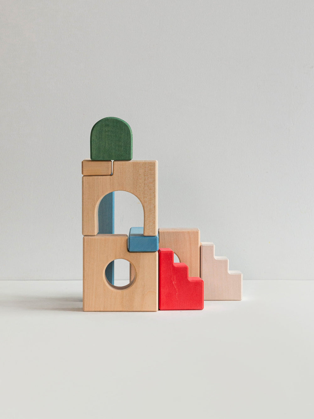 Colorful wooden building blocks and staircase blocks on a light gray background
