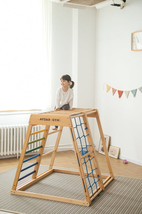 A girl sit on the rainbow climber