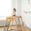 A girl sit on the rainbow climber