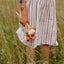 A girl grabs a bunch of wooden flowers in pink,white and orange