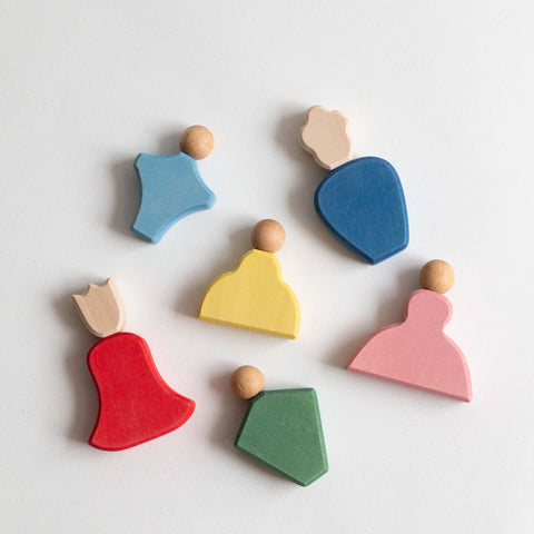 Colorful wooden toys shaped like people on a white background