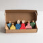 Set of colorful peg dolls in a cardboard box on a white background