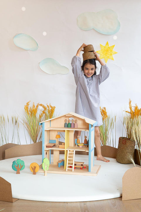 A girl play the wooden dollhouse with featuring two stories, an attic, and a balcony. 